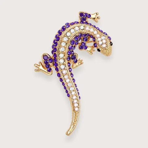 Y2K guldfarvet gekko-broche med lilla rhinsten · Trendbrocher 2026 — produktfoto